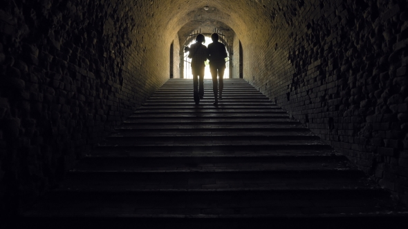 Silhouette Of Women Going Away In a Dark Tunnel