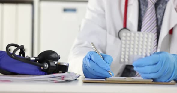 Doctor Holding Blister with Pills in Hands and Writing Prescription in Clinic  Movie Slow Motion alt