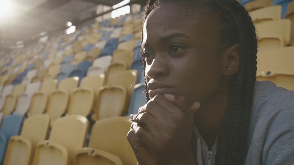 Portrait Of Young African American Train Woman Sitting At The Stadium And Fixedly Look For