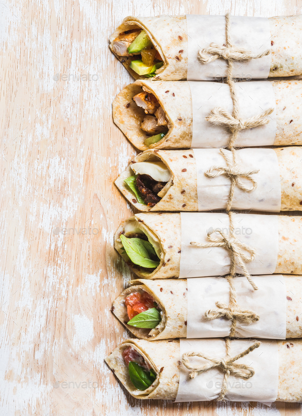 Tortilla wraps with various fillings on shabby white wooden board - Stock Photo - Images