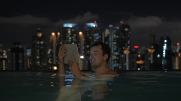 Man With Pad In Rooftop Pool Of Night Kuala Lumpur alt
