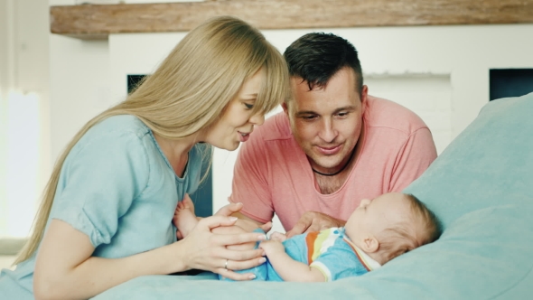 Young Mom And Dad Looking At Sveogo Baby alt