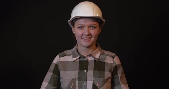 Young Female Engineer Puts on Protective Glasses.