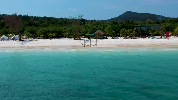 Aerial pan along white sand beach with turquoise blue sea. Koh Rong, Cambodia alt
