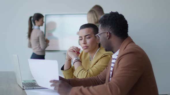 Handsome young African American business man and short hair woman working on laptop