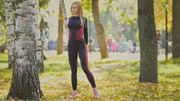 Sexy Attractive Female Blonde Bikini-fitness Model Stretching In The Autumn Park On Ground Covered