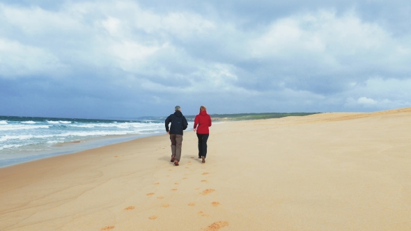 Middle-aged Couple Jogging On Beach