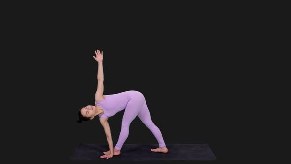 Young Woman Doing Revolved Triangle Pose while Practicing Yoga, Alpha in