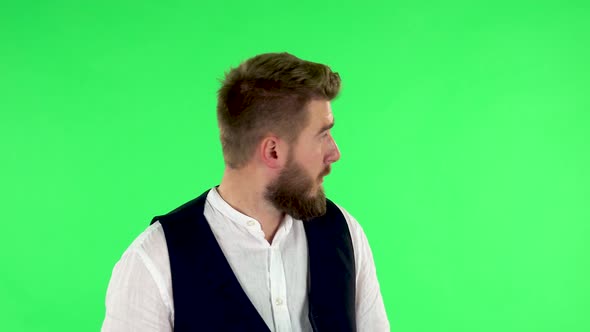 Man Looks Around, Covers His Mouth with His Hand and Whispers the Secret and Making a Hush Gesture alt