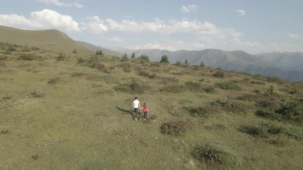Father And Daughter Wandering In Alpine Meadows alt