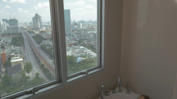 In The City Of Bangkok, Thailand Young Girl In Apartment By Window Taking a Bath alt
