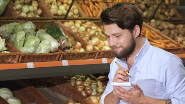 Man Write In His Notebook At The Supermarket alt