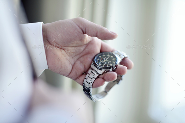 Groom is wearing a wrist watch indoors