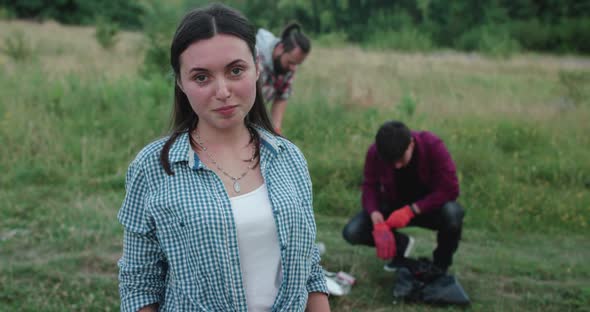Smiling Girl Shows and Waves Hands in Gloves at Camera During Cleaning Nature alt