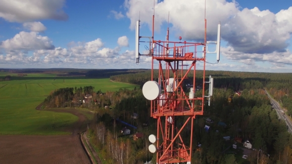 Aerial view of a telecommunication cell phone tower standing next to the village