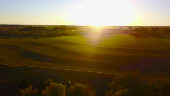 Aerial drone shot of a tiered wheat field in Kingman, Kansas, at sunset. The field is about 30 minut alt