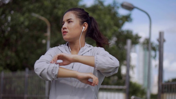 Asian fitness runner sportswomen stretching and preparing in the urban city to run.