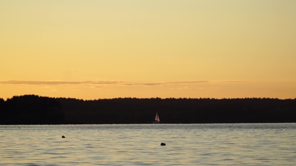 A Small Sailing Boat on the Water at Sunset