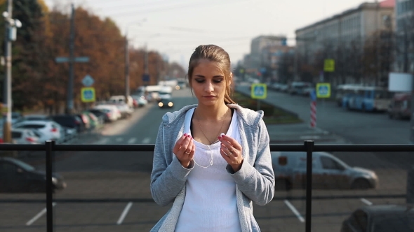 Young Girl Wears Headphones Before Jogging Around The City