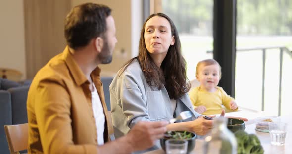 Young Family with a One Year Baby Boy During a Lunch Time at Home alt