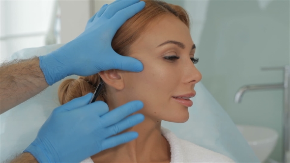 Cosmetologist Stretches The Skin On Client's Cheek alt