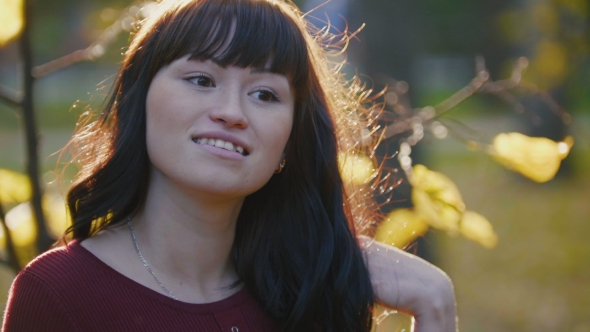 Cute Young Pregnant Woman Standing At Autumn Park Among Golden Leaves, Smiling And alt