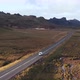 Small transporter van driving in remote valley on empty road in Iceland, aerial - VideoHive Item for Sale