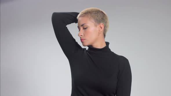 Blonde with Short Haircut in Studio Poses for Camera on Grey Ideal Skin