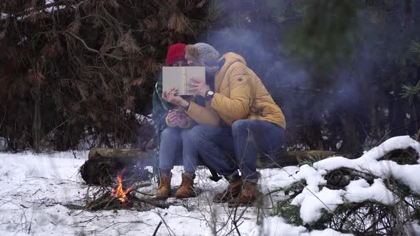 Guy and Girl Read a Book in Winter in the Forest alt
