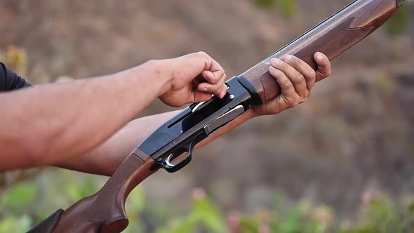 Close Up of a Hunter Hands Unloading a Shotgun. Slow Motion. alt