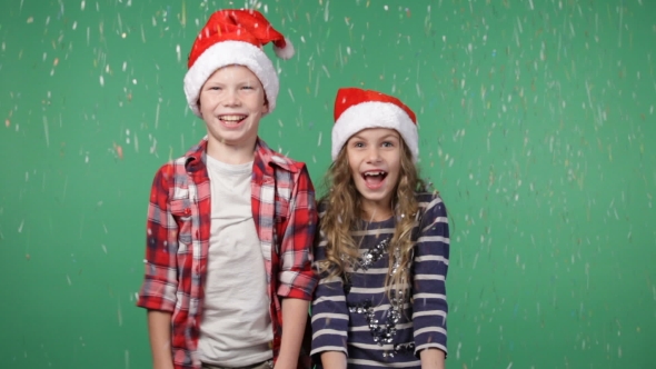 Children In Christmas Caps Throwing Up Confetti alt