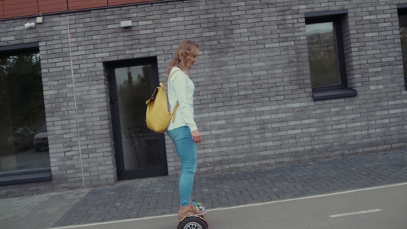 Young Woman Using Gyroscooter Platform. Bright Yellow Backpack