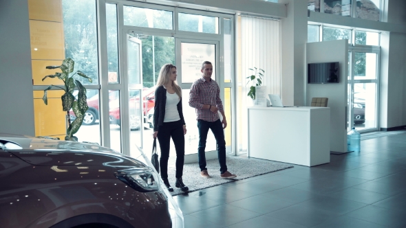 Couple Entering In Car Dealership To Chose Car alt