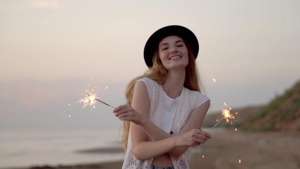 Teenage Beautiful Girl With Sparklers On The Beach At Sunset alt