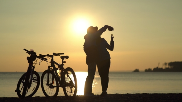 Romantic Couple At Sunset. Silhouette Of Bicycles On Sunset.