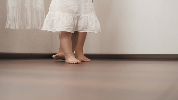 Caucasian Mother Supporting Her Little Baby Practicing Her First Steps alt