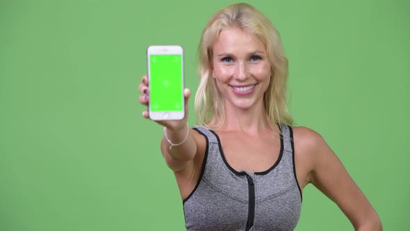 Young Happy Beautiful Woman Showing Phone Ready for Gym