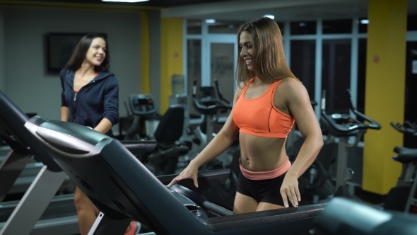 Two Fitness Girls On Running Machines alt