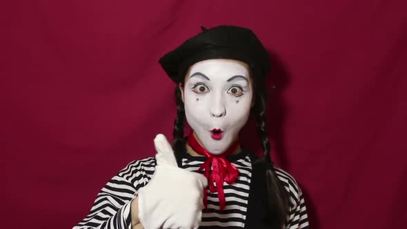 Beautiful Girl Mime Smiles, Shows Thumb Up and Nods Approvingly While Looking at the Camera.