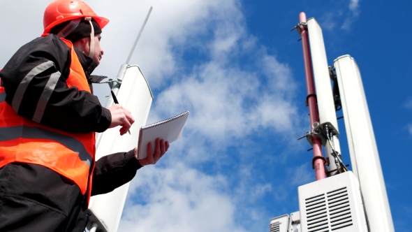 A Technician Works On Cellular Tower. The Tower With To The Antennas Of Mobile Phone Communication,