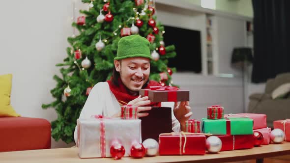 Surprise Asian men open the gift box in the living room.