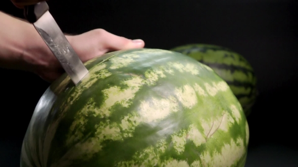 Man's Hand Cutting Huge Watermelon alt