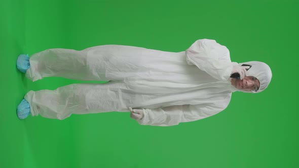 Full Body Of Asian Man Wear Protective Uniform Ppe Talking On Mobile Phone In Green Screen Studio alt