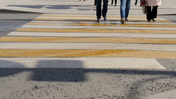 People Cross The Road At a Pedestrian Crossing