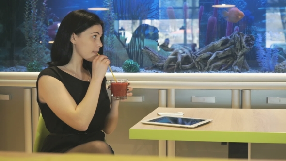Girl Sitting At a Cafe And Drinking a Juice