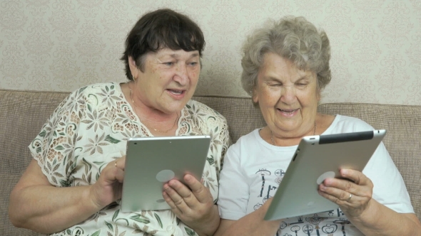 Two Old Women Holding The Silver Digital Tablets