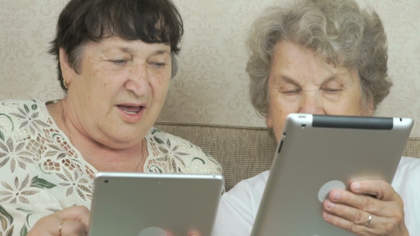 Two Elderly Grandmothers Holding Digital Tablets