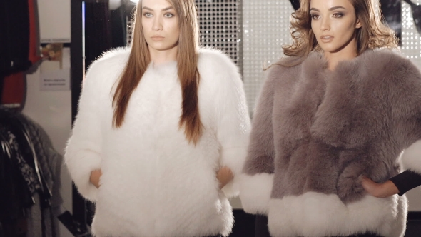 Two Models Posing In Fur Coats In Fashionable Rich Boutique. Slowly alt