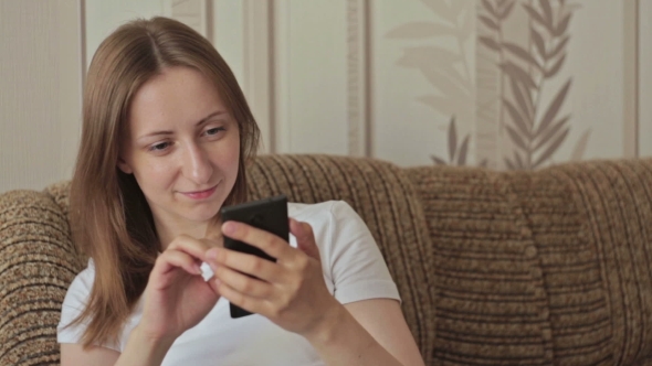 Young Woman Using Mobile Phone At Home alt