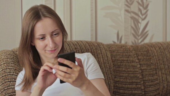 Young Woman Using Mobile Phone At Home